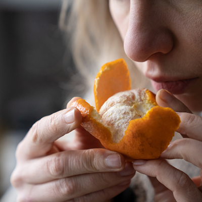 Sieviete smaržo apelsīnu.